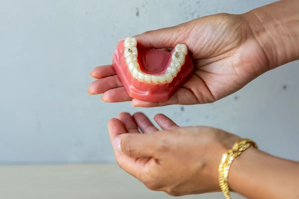 Heritage House Dental clear Invisalign aligner trays held by hands in Mississauga, ON